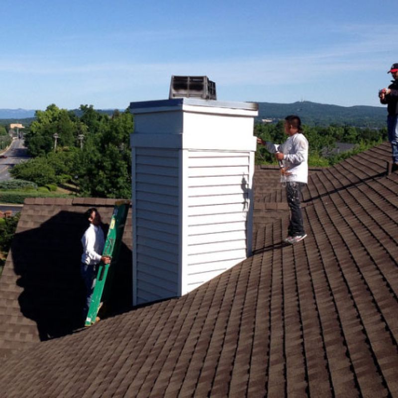 Workers are installing siding on this exterior chimney.